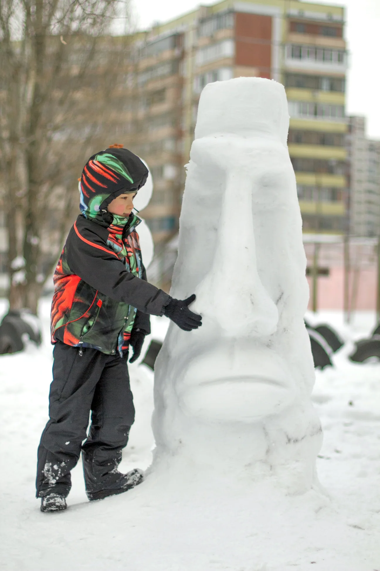 kid-creating-snowman-as-a-part-of-winter-outdoor-activities